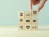 Hand stacking wooden cubes with inscripted employee benefit icons.